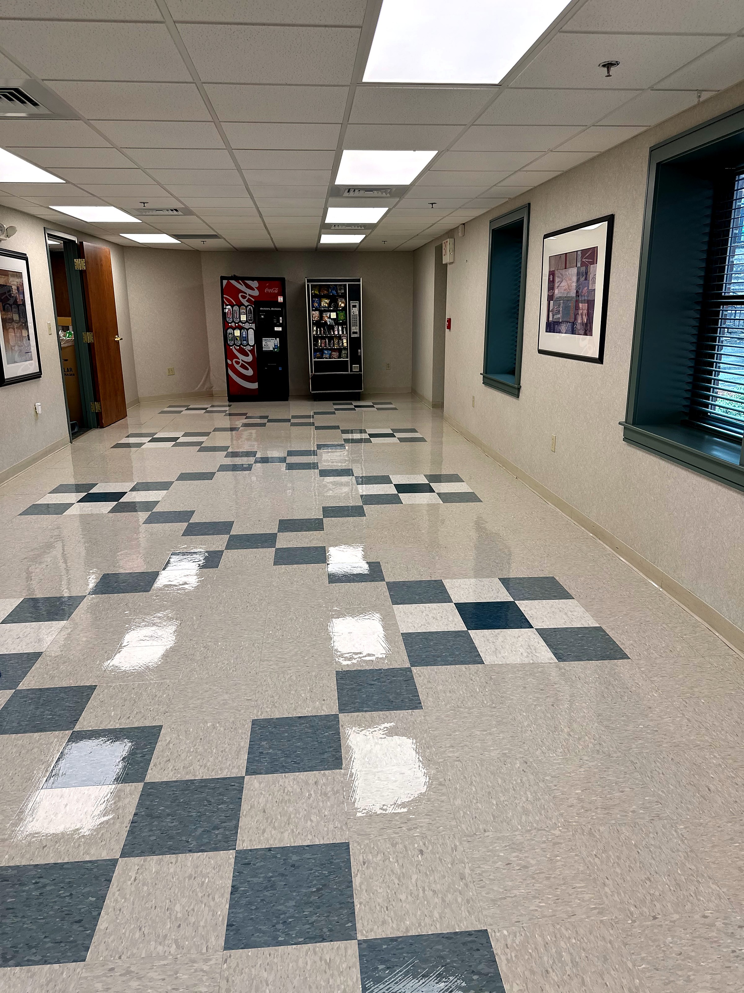 A lobby corridor with a burnished checkerboard tile floor.