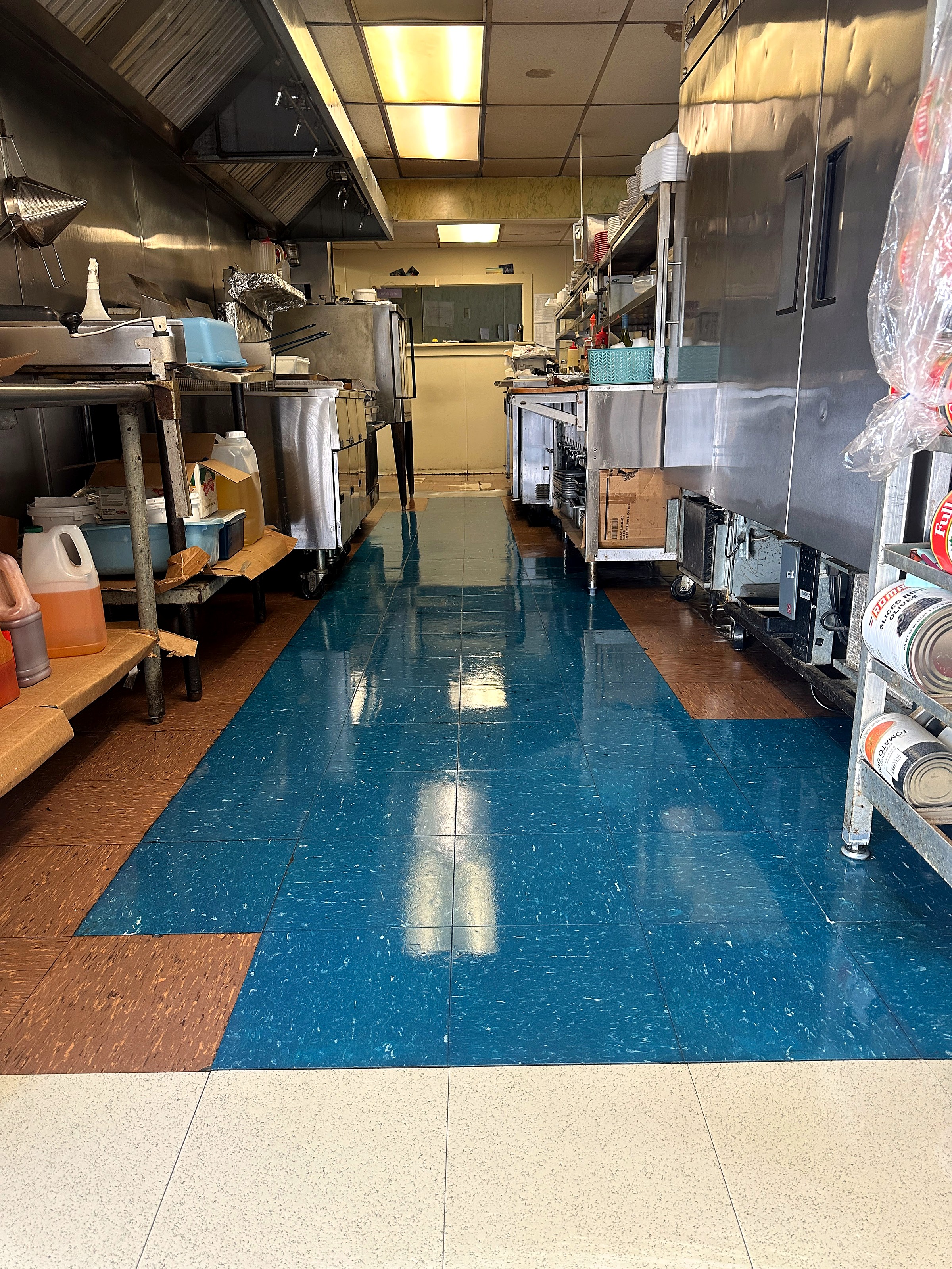 A commercial kitchen with a clean, polished blue tile floor.